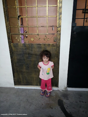 Picture of Sakinah standing in front of the door waiting for mummy to open the door.