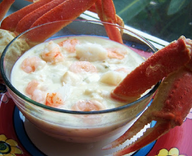 this is a bowl of delicious crab legs, shrimp and other seafood all in a big glass bowl called chowder. This seafood medley of chowder is rich and delicious often made at Christmas eve as a special Holiday  treat
