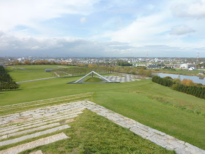 Two sides of play mountain as seen from the top of play mountain with the tetra mound in the background at Moerenuma Park (Moerenuma Koen), Sapporo