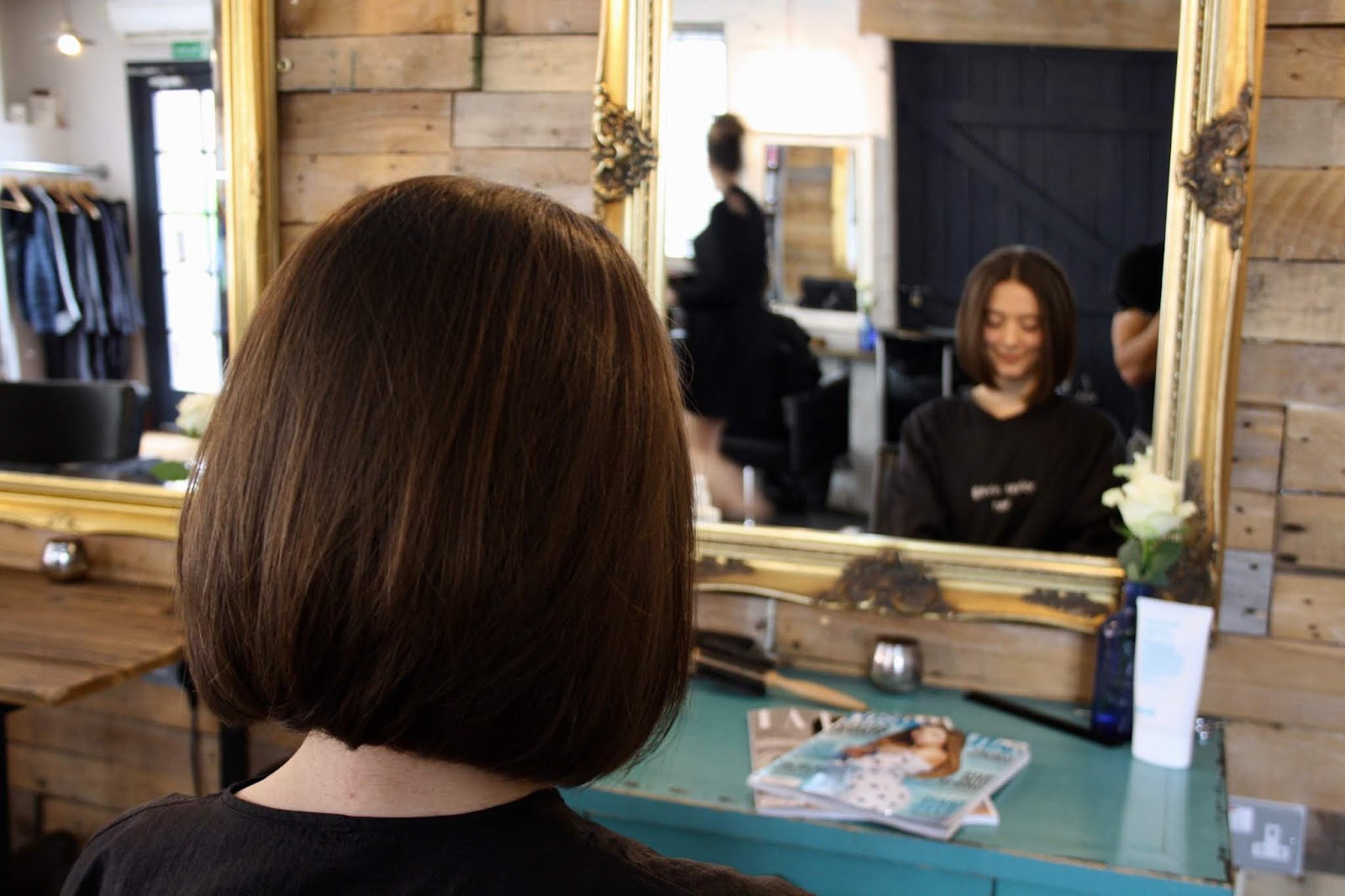 Abbey, with a sleek brunette haircut, sits facing a gold mirror in the Gavin Taylor Hair salon