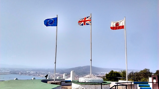 Photo of the European Union (EU), United Kingdom (UK), and Gibraltar flags flying side by side. Gibraltar is the only British territory that's also part of the EU.