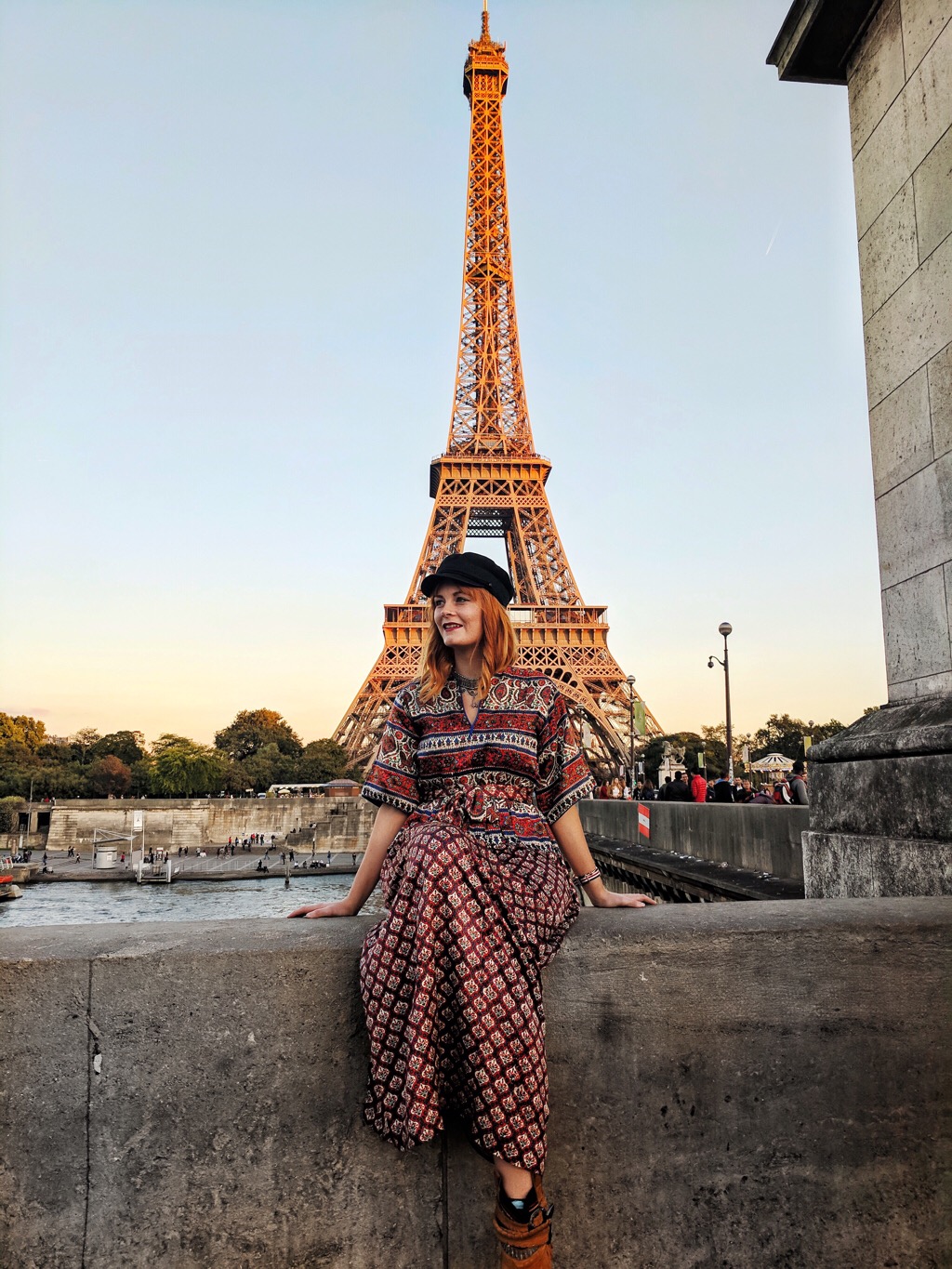 Travel blogger, Leigh Travers, sits in front of the Eiffel Tower
