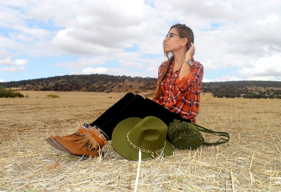 Camisa de cuadros con vaqueros rotos, botas boho, sombrero y bolso