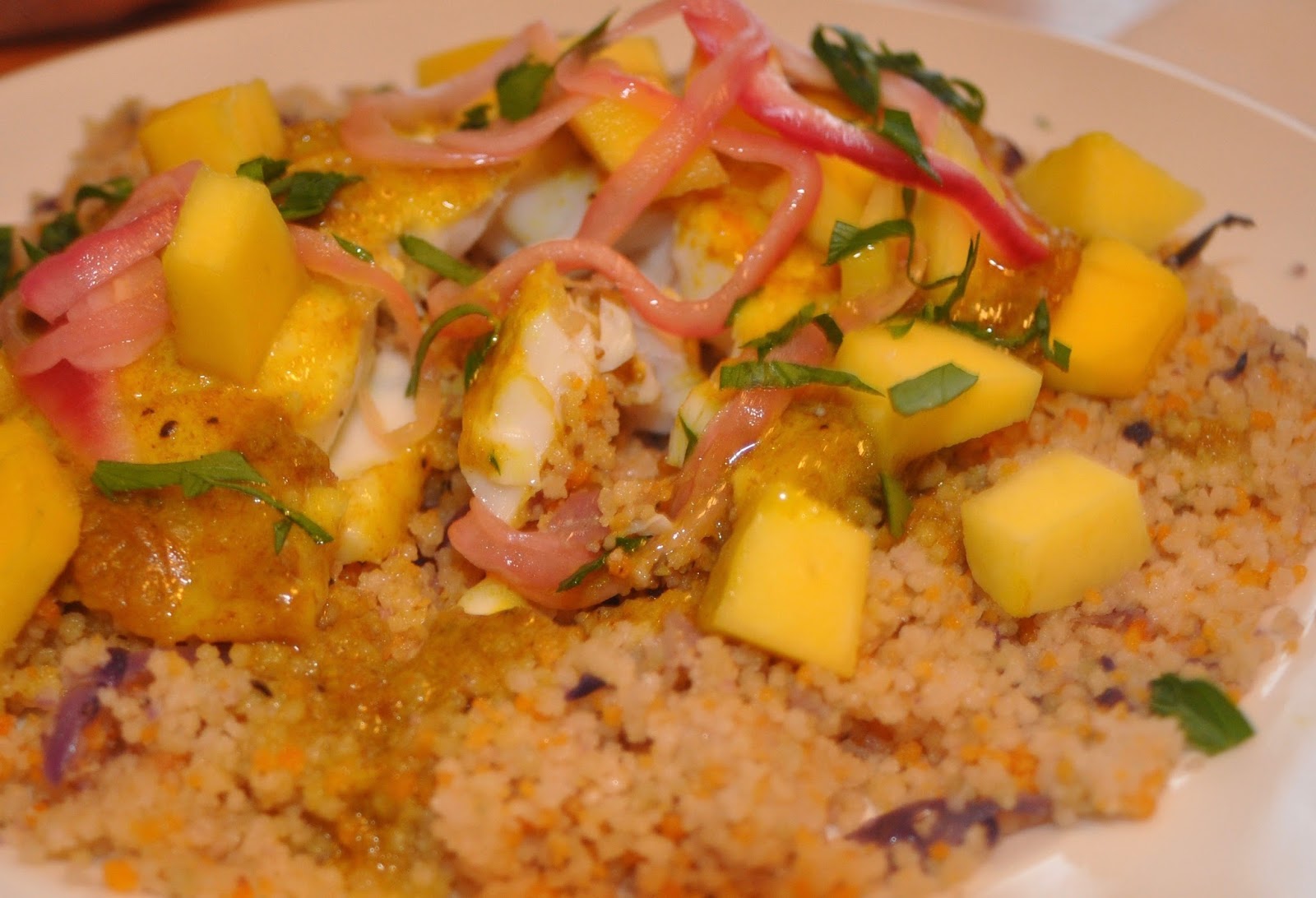 Tilapia poached in spicy coconut milk with couscous, mango and pickled red onion