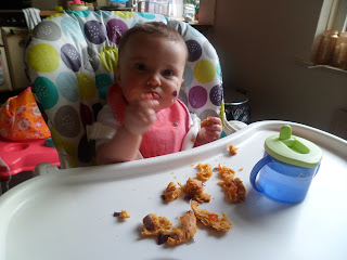 Baby eating cheese, tomato and red onion scones.