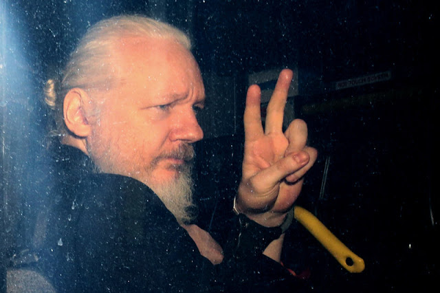 WikiLeaks founder Julian Assange arrives in a police vehicle at Westminster Magistrates court on Thursday in London. He was arrested by Scotland Yard Police Officers inside the Ecuadorian Embassy in Central London-top world news reports.