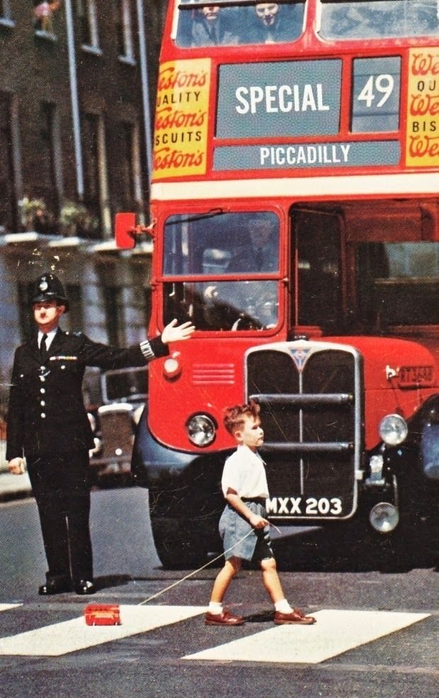 A boy crosses a London street in the 1960s with a toy double decker. - The 63 Most Powerful Photos Ever Taken That Perfectly Capture The Human Experience