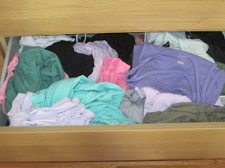 Messy drawer of t-shirts and tanks