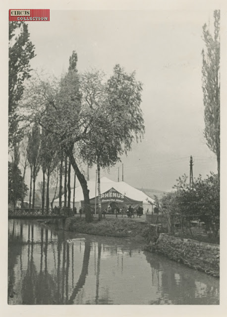 le chapiteau et la tente d'entrée du cirque se reflète dans l'eau de la rivière 