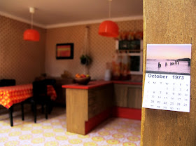 Modern dolls' house miniature 1970s-style kitchen, with a calendar from 1973.