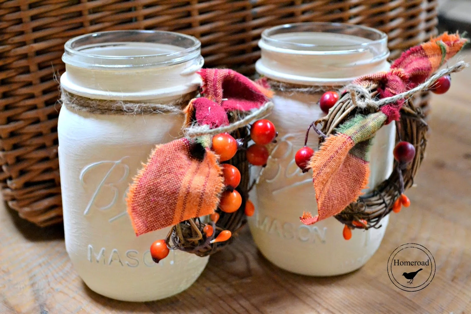 2 white mason jars with wreaths and ribbon