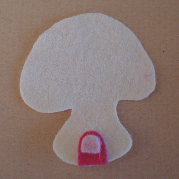 Front felt mushroom piece cut out in cream color with pink door