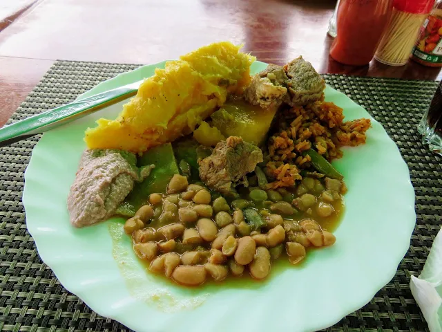 Plate of Ugandan cuisine including matoke and beans