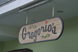 A playful font on a wooded sign hanging from the roof.