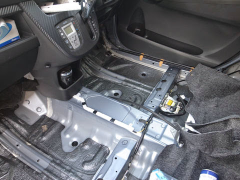 助手席側から見たフロアマット取り外した様子 la100sムーヴカスタムフロアのデッドニング フロント側は意外に多くの制振材(黒いのがそうです)が使われている事が解ります。それ以外の部分にレアルシルト制振材を貼り、サンダム防音シートを敷いて、シンサレートを入れて戻していきます。