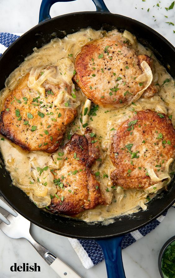 We want our pork chops like we want to be loved: smothered. Get the recipe at Delish.com. #recipe #easy #easyrecipes #delish #pork #chops #porkchops #dinner #easydinner #dinnerrecipes #smothered #onions #pig