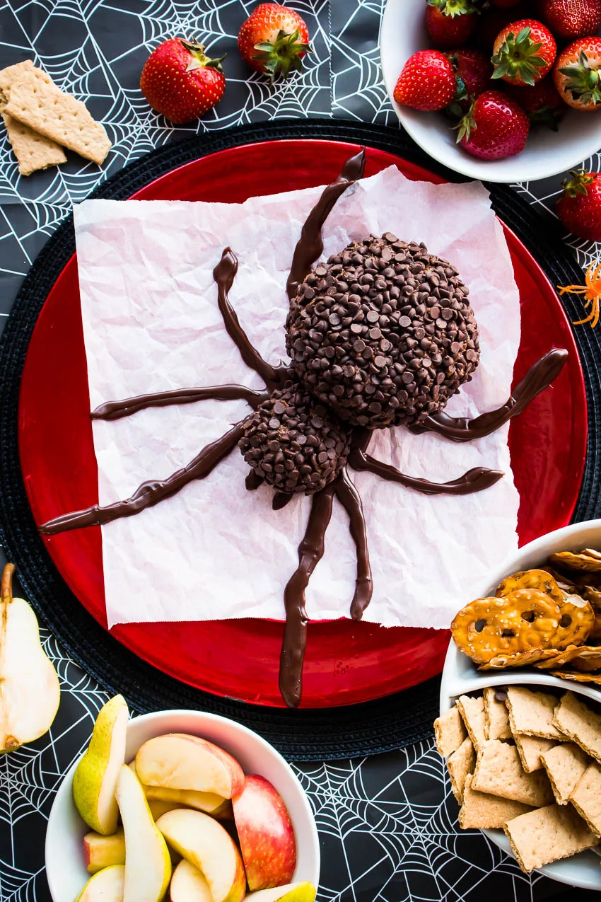 A Spooky Spider Chocolate Cheese Ball will be the hit of your Halloween party!  This festive, easy to make, spider-shaped cheese ball is made with cream cheese, peanut butter, and lots of chocolate chips. #Halloween #cheeseball #dessert