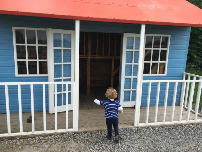 Walnut-tree-farm-park-A-Toddler-Entering-wooden-playhouse
