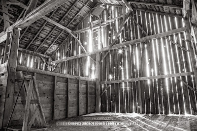 An interior view of a rustic old barn as the setting sun shines in through the cracks in the barn board captured by Chris Gardiner Photography www.cgardiner.ca