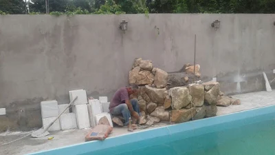 Bizzarri fazendo uma cascata de pedra na piscina com pedras ornamentais tipo pedra moledo bege.