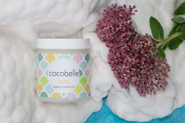 A jar of Cocobelle Baby on a blanket and next to flowers