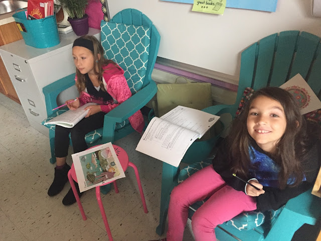 two kids in teal chairs working on math