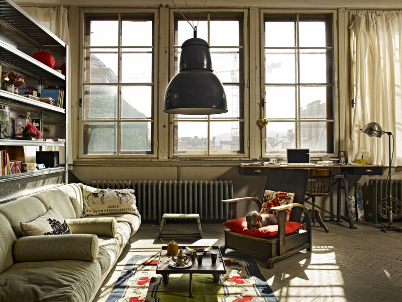 Salón con grandes ventanas en un mini loft vintage- industrial