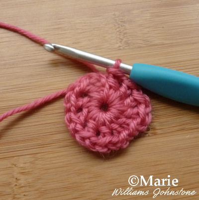 Circle of dark pink yarn on the hook shank