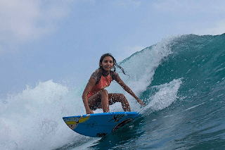 Girl surfing on the beach watu karung