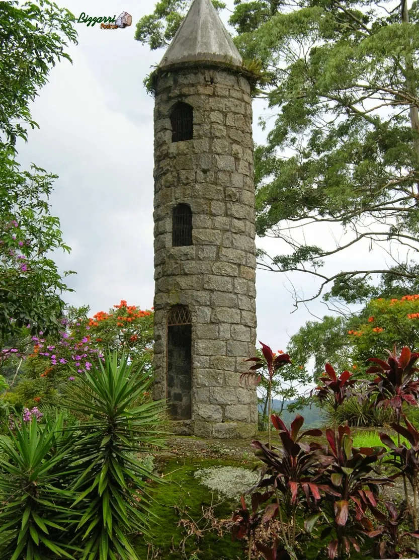 Detalhe da torre de pedra com parede de pedra com pedra do tipo folheta e a execução do paisagismo.
