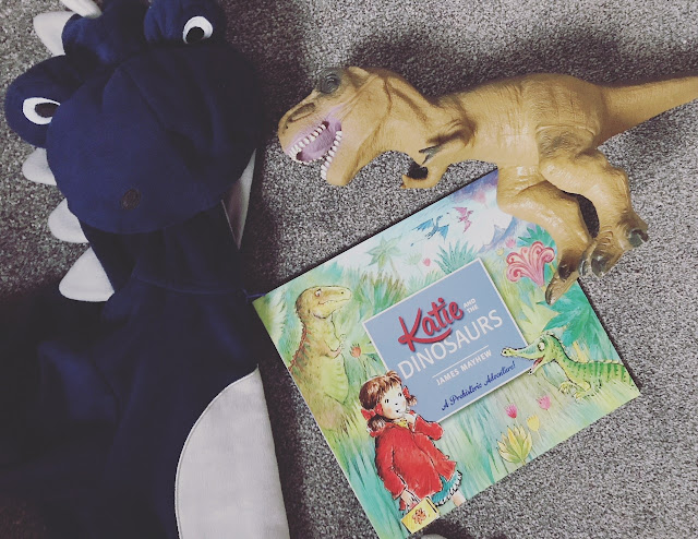 A copy of the book with dinosaur costume and toy dinosaur