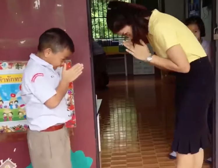 Teacher earns praise for greeting children with special handshake before class