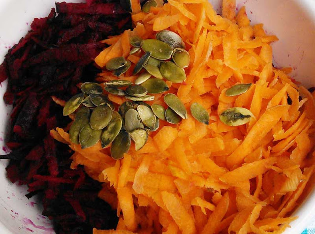 Geraspelte Rote Beete, geraspelte Karotten bestreut mit Kürbiskernen