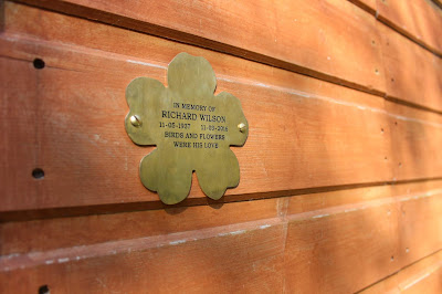 Brass flower plaques mounted on a wooden wall
