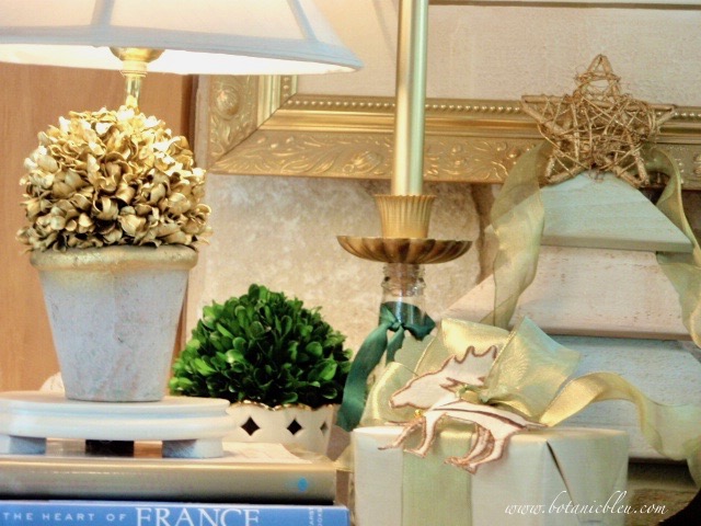 Muted green and gold items create a Christmas vignette for an unusual color scheme