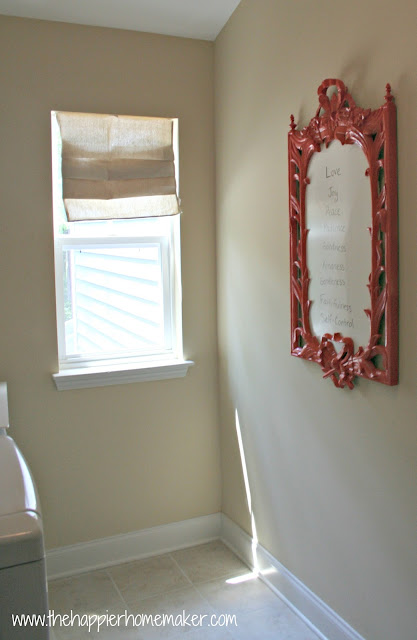 A laundry room with a red wood frame being used as a dry erase frame