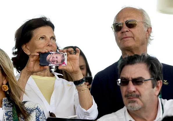 Queen Silvia take a photo with here phone, which features a picture of her granddaughter Princess Estelle