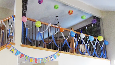 Birthday party tissue paper pom-poms, balloons, and streamers