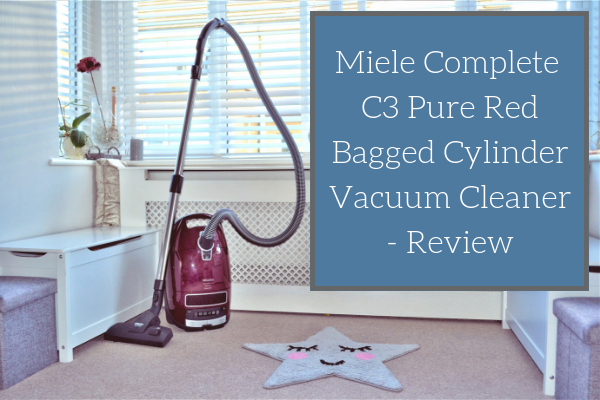 Miele Complete C3 Pure Red Bagged Cylinder Vacuum Cleaner standing upright in the corner of my lounge with the blog post title displayed