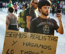Pancarta, manifestante y móvil (Juan Luis Sánchez)