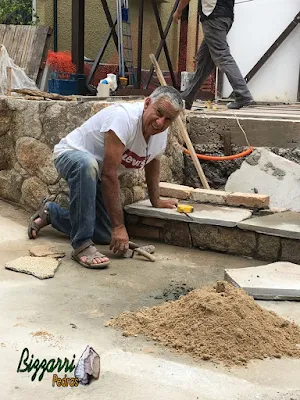 Bizzarri, da Bizzarri Pedras, trabalhando, fazendo a construção da escada de pedra com pedra Carranca sendo tipo cacão nas pisadas da escada e nos espelhos da escada a chapa de pedra moledo no mesmo estilo do muro de pedra.