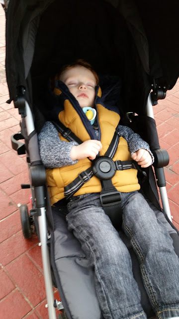 Toddler napping in a pushchair