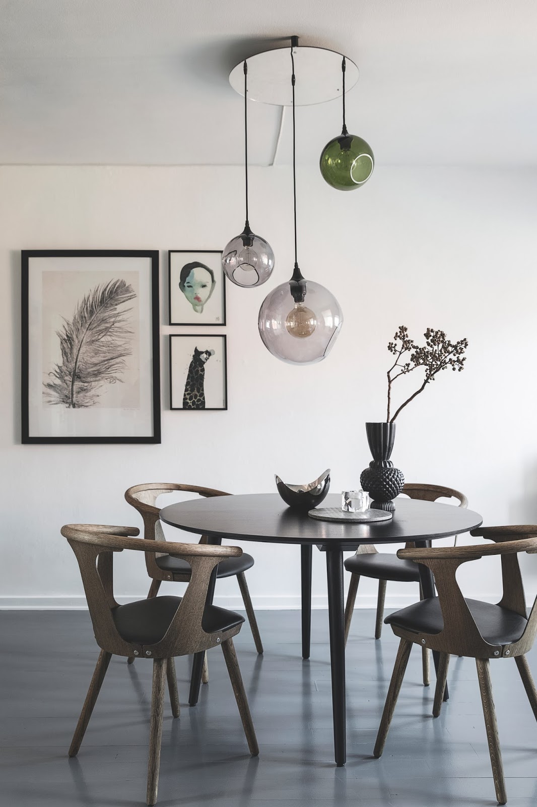 dining room in nordic apartment, gallery wall, design chairs and glass ceiling lamp