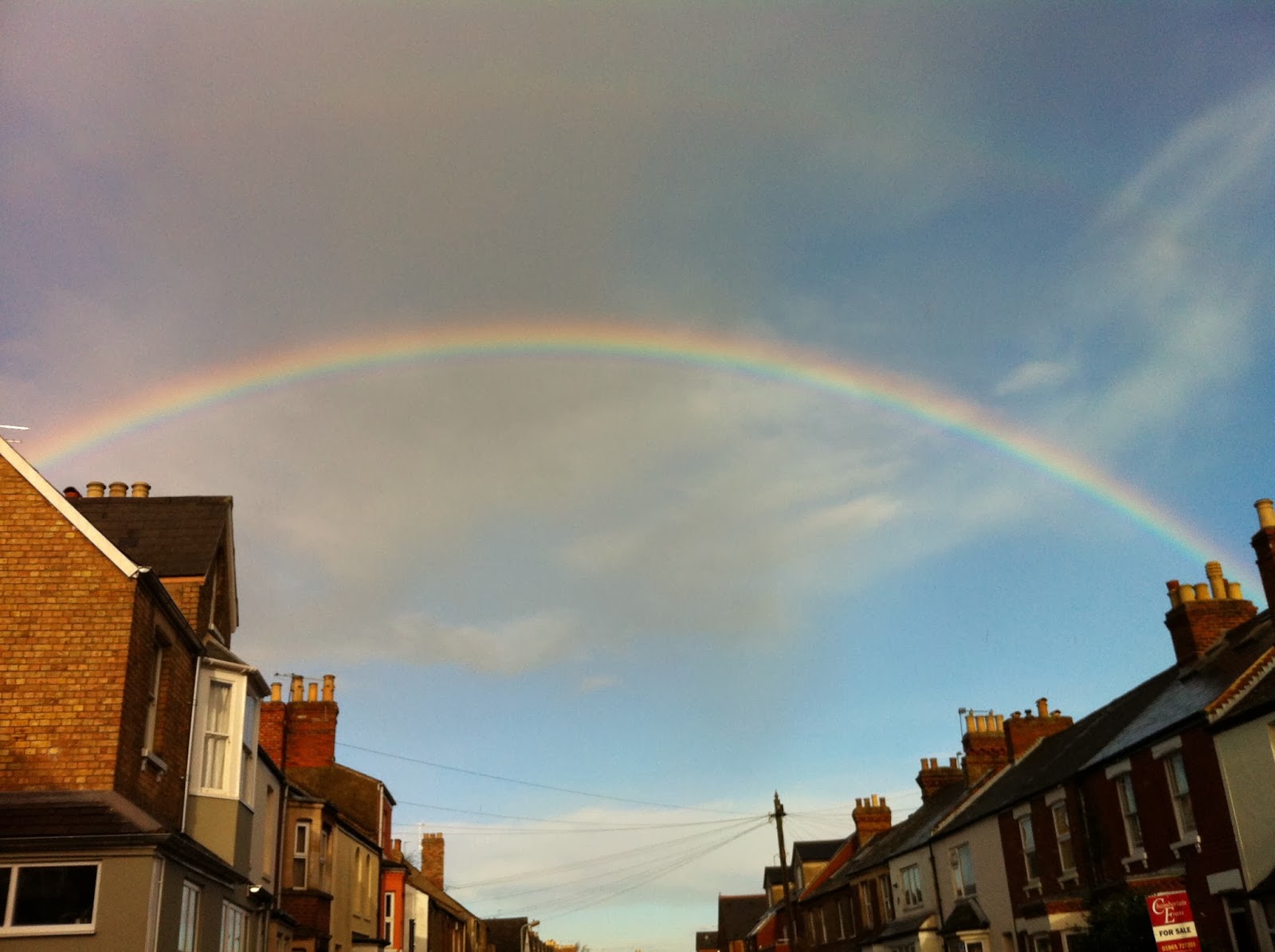 Rainbow over street of houses