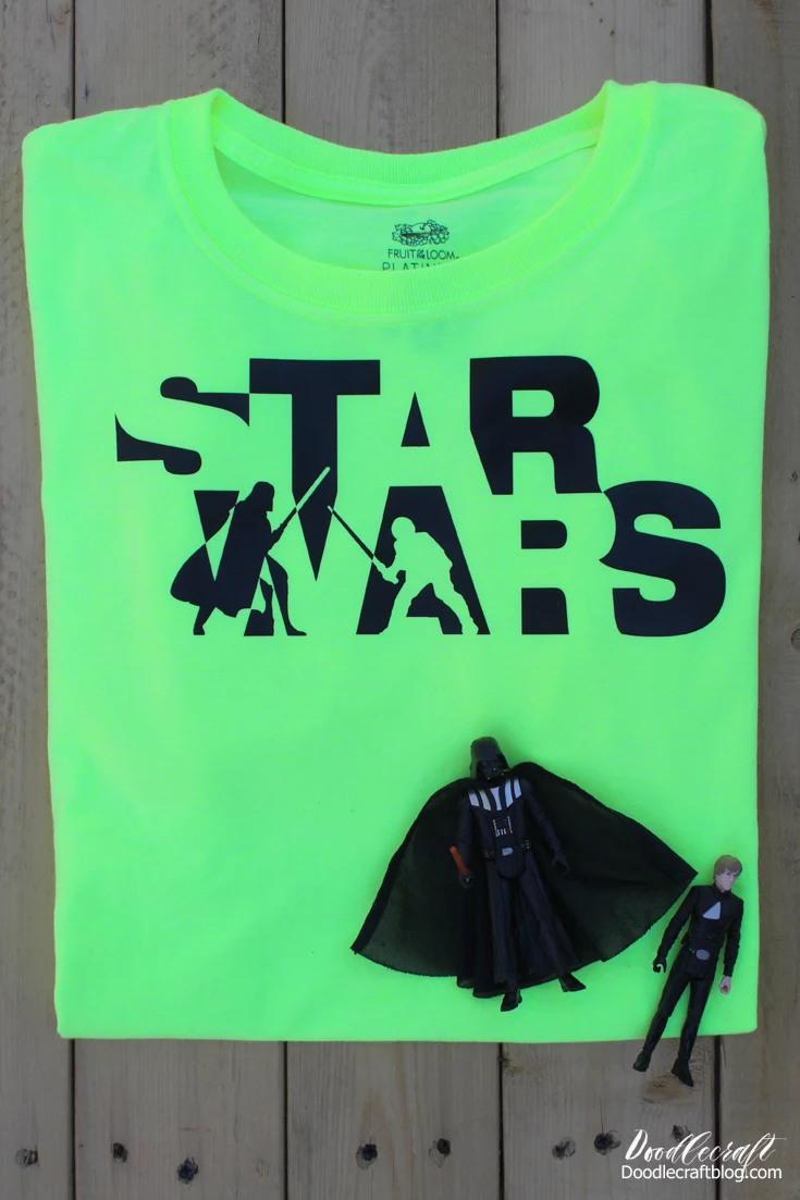 Neon green shirt with black star wars logo with darth vader and luke skywalker engaged in a lightsaber duel.