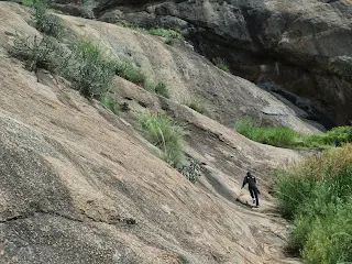 Hiker tries scale a sheer vertical rock face at the Narayanagiri Trek