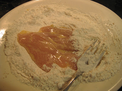 chicken breast sitting on plate of flour
