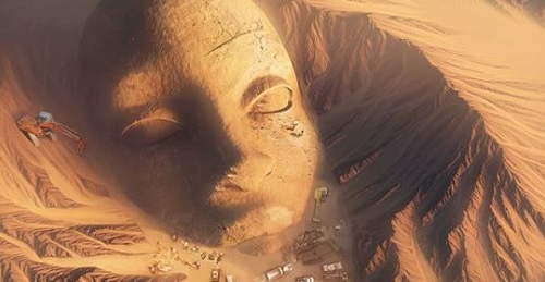 giant head in desert partially excavated by cranes
