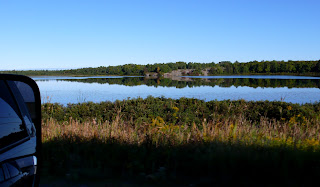 View out the window of a small lake along the roadway