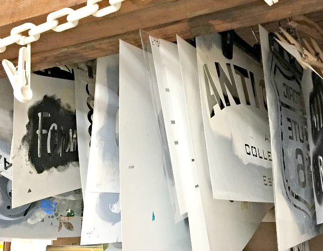 stencil storage in a basement workshop using plastic hangers.